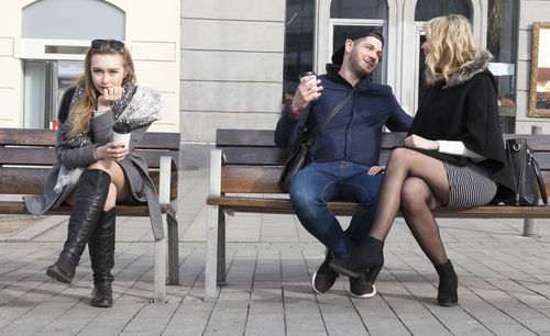 Young couple sitting on chair in city