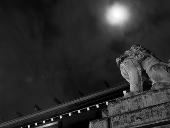 Low angle view of statue against sky at night