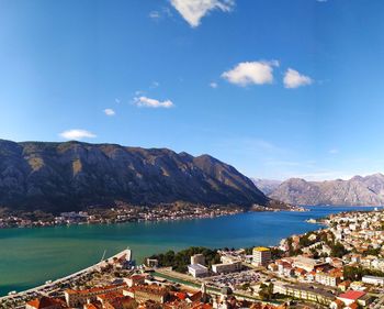 Aerial view of city by sea against sky