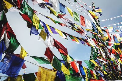 Low angle view of flags hanging against sky