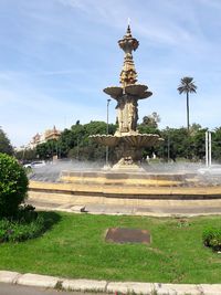 Fountain in front of building against sky