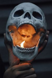Close-up of hand igniting human skull