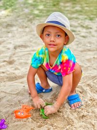 Portrait of cute boy playing with toy on sand