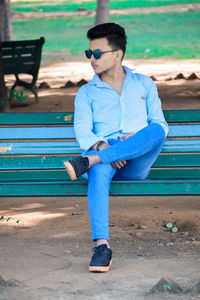 Full length of young man sitting on bench