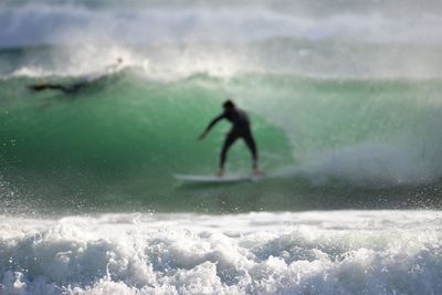 Man surfing on waves in sea