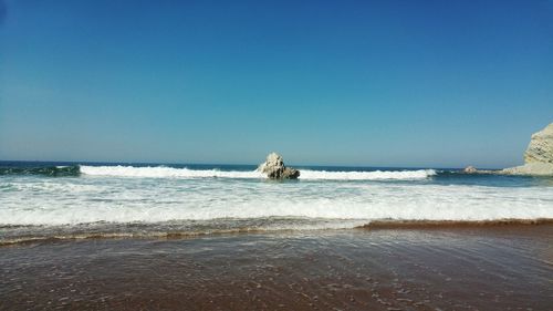 Scenic view of sea against clear blue sky