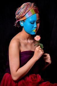 Young woman looking away against black background