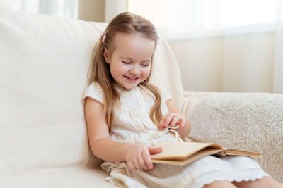 Cute girl reading book at home