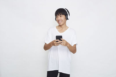 Young man using mobile phone against white background