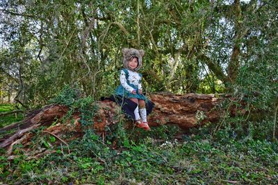 Portrait of boy standing on field in forest