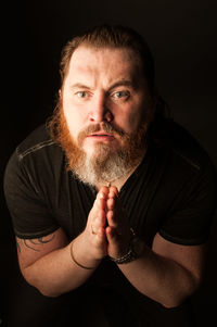 Portrait of man against black background