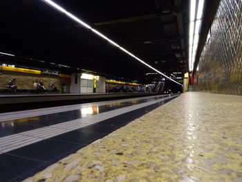 Illuminated railroad station platform at night