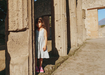 Rear view of girl standing between columns 