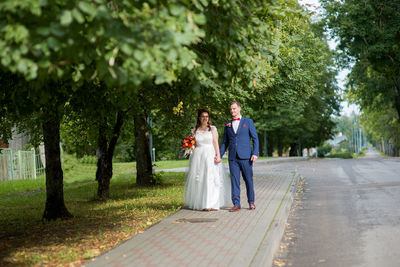 Bride and groom walking at park