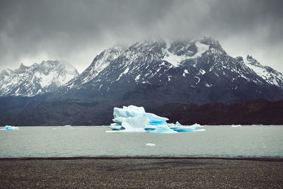 Snow on landscape against mountain range