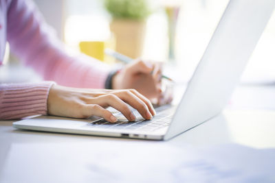 Midsection of man using laptop on table