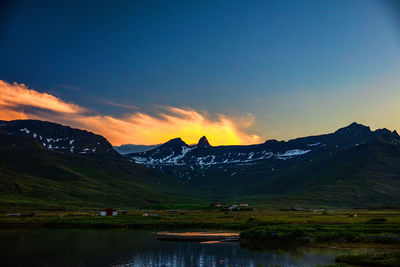 Scenic view of lake and mountains against sky during sunset