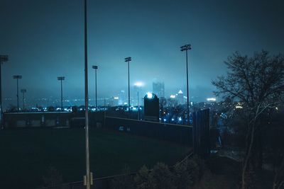 Illuminated street light against sky at night