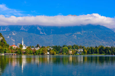 Scenic view of lake by buildings against sky