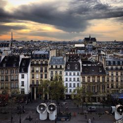 View of cityscape against cloudy sky