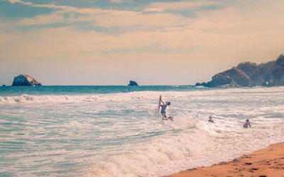 People on beach against sky