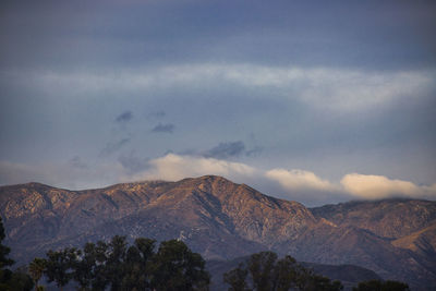 Scenic view of mountain range against cloudy sky