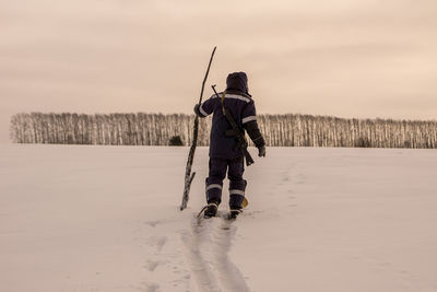 Rear view of man on snow covered land