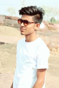 Young man wearing sunglasses standing outdoors