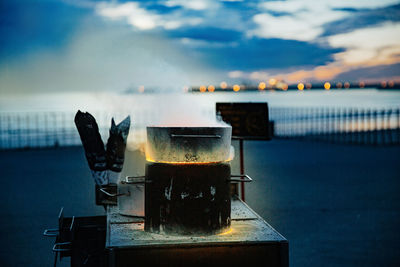 Close-up of barbecue grill on table against sky during sunset