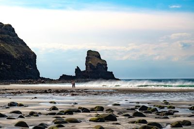 Rocks on beach against sky