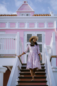 Full length of woman standing on staircase against building