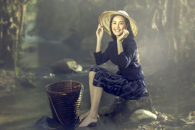 Woman wrapped in fabric sitting on rock