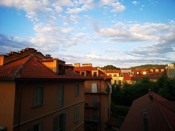 Houses in town against sky during sunset