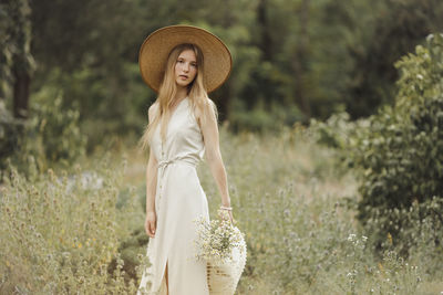 Woman wearing hat standing on field