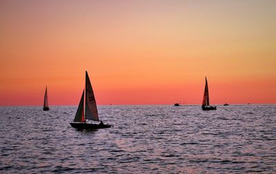 Boat sailing in sea at sunset