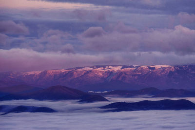 Scenic view of snowcapped mountains against dramatic sky