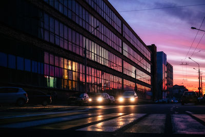 View of city street against sky at sunset