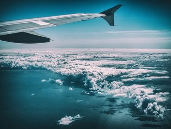 Cropped image of airplane flying over sea