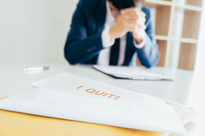 Midsection of woman reading book on table