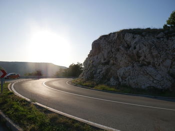 Road by mountain against sky