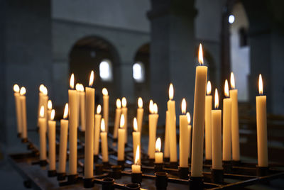 Illuminated candles in church against building