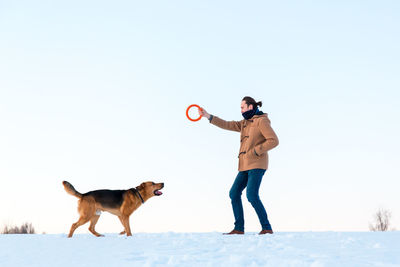 Full length of dog on snow against sky