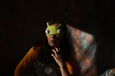 Woman wearing sleep mask at home