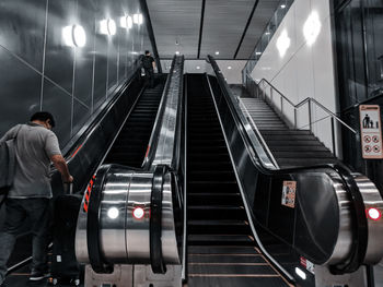 Rear view of man on escalator