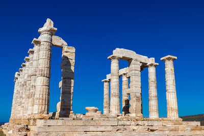 Low angle view of old ruins against blue sky