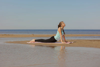 Full length of woman sitting on beach