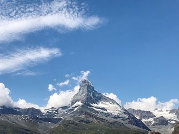 Scenic view of snowcapped mountains against blue sky