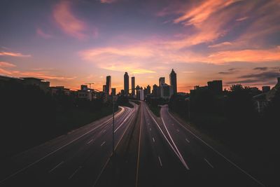 High angle view of street amidst buildings against sky during sunset