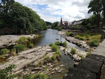 Scenic view of river by building against sky
