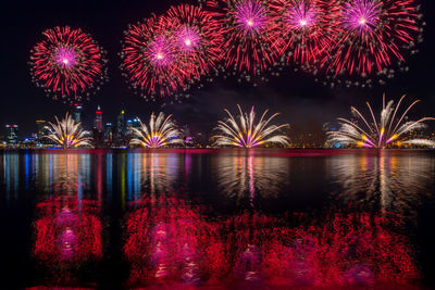 Firework display over river at night